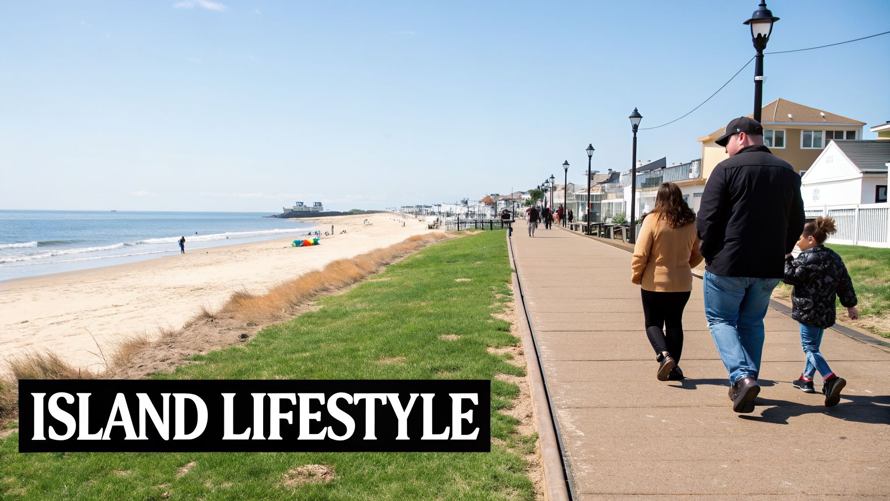 A family walks along a sunny boardwalk next to a sandy beach and the ocean.