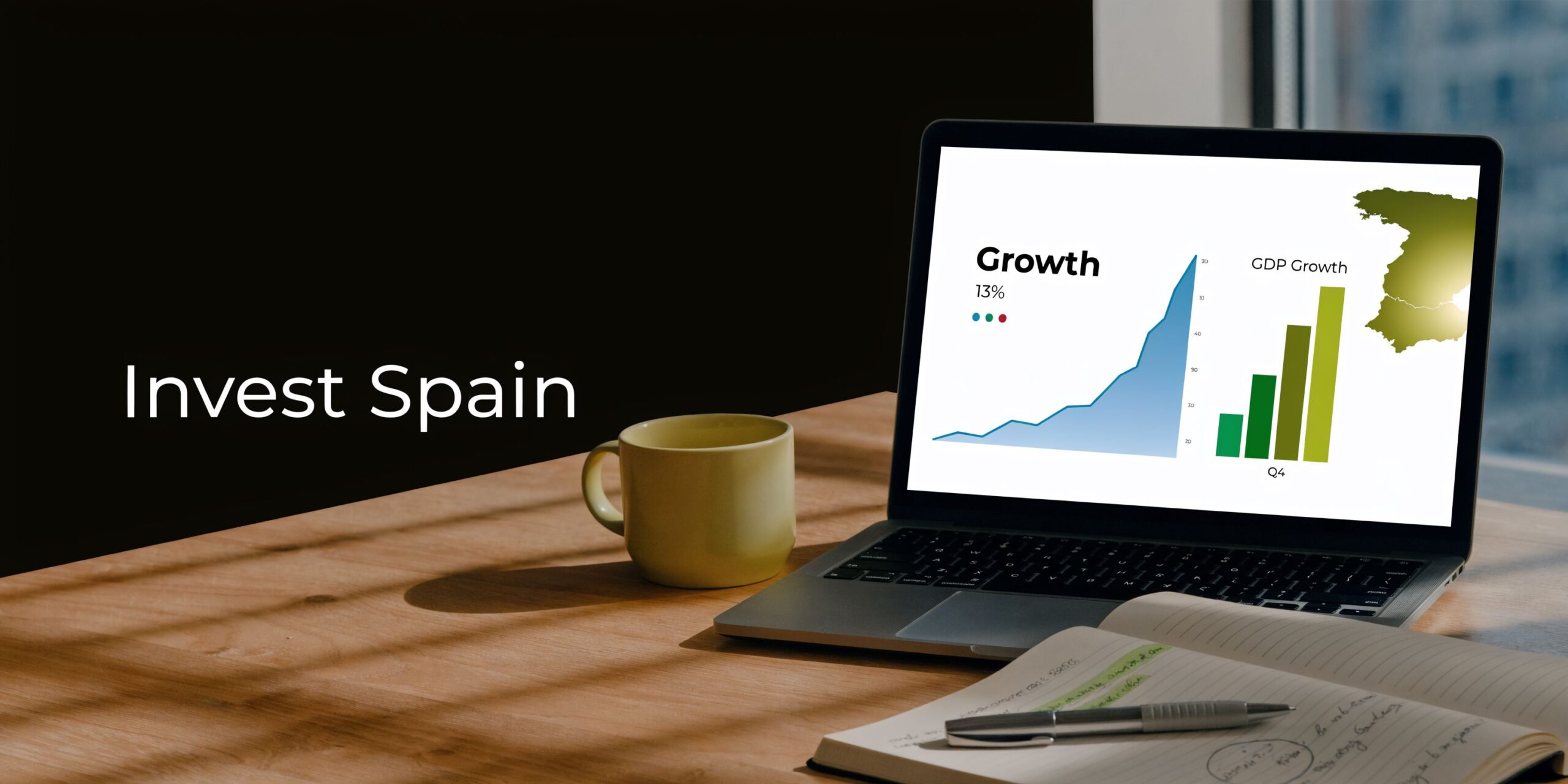 A laptop on a wooden desk showing a GDP growth chart for Spain with a coffee cup nearby.