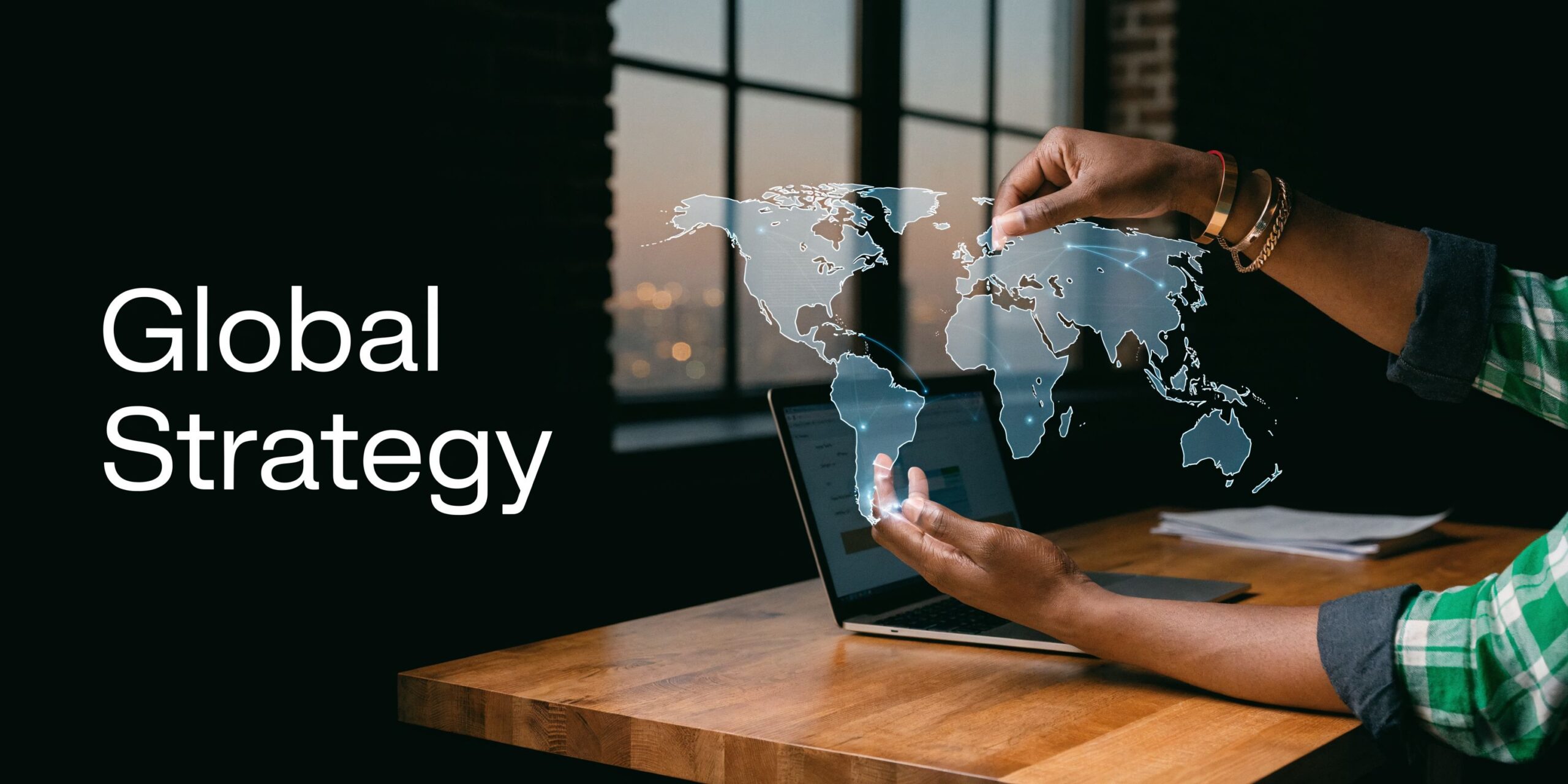 A person using a holographic map for global business strategy planning on a laptop computer.